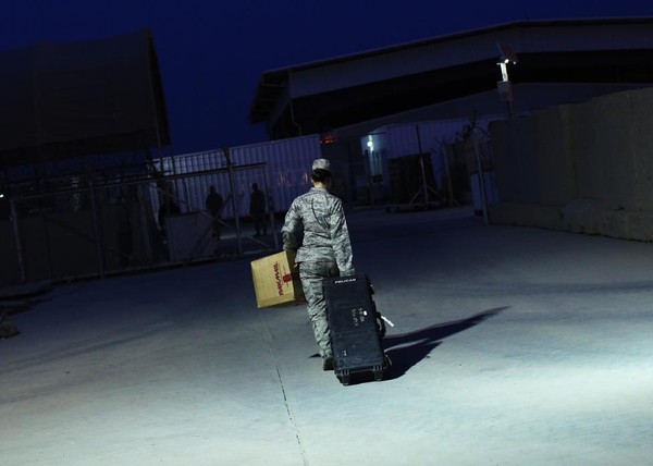 Thiếu tá Stacie Shafran thuộc lực lượng không quân xách hành lý lên khoang trong lúc đợi máy bay khởi hành ở căn cứ không quân Sather gần Baghdad, Iraq.